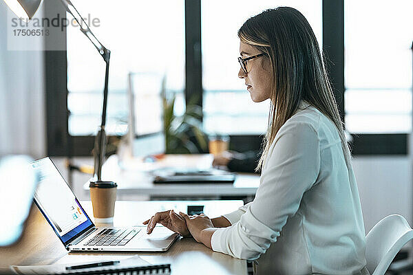 Geschäftsfrau benutzt Laptop am Schreibtisch im Büro