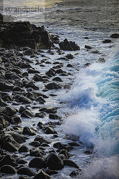Wellen plätschern gegen die felsige Küste von Praia de Santa Barbara