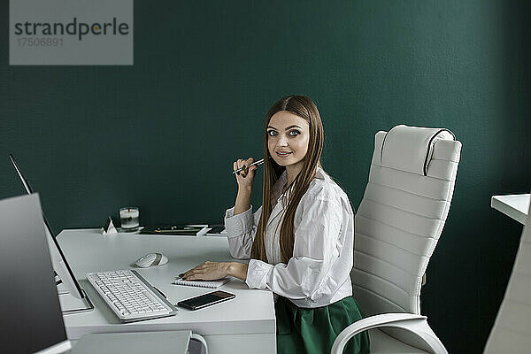 Geschäftsfrau sitzt am Schreibtisch im Büro