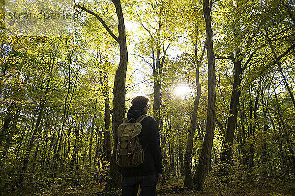 Wanderer mit Rucksack steht im Wald