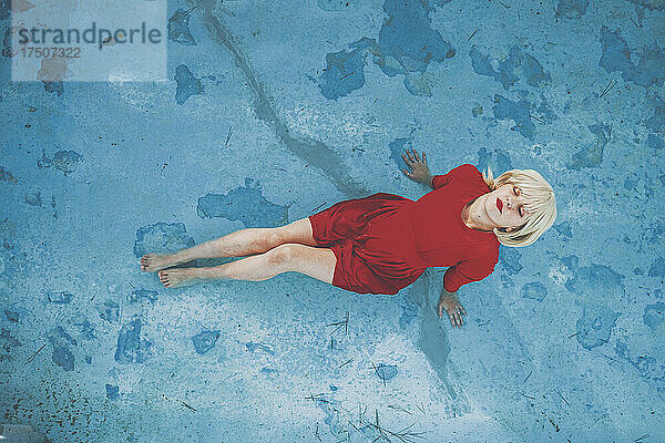 Frau mit geschlossenen Augen entspannt sich im Schwimmbad