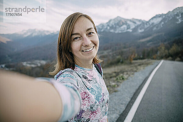 Lächelnder Wanderer macht Selfie auf Bergstraße