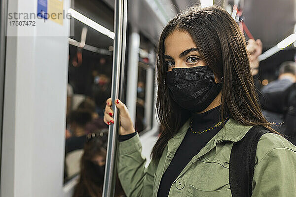 Frau mit schützender Gesichtsmaske in der U-Bahn