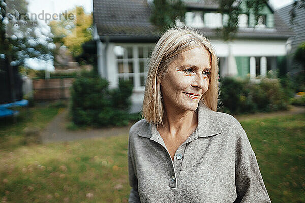 Blonde Frau blickt in den Hinterhof