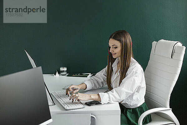 Geschäftsfrau arbeitet am Schreibtisch im Büro am Desktop-Computer
