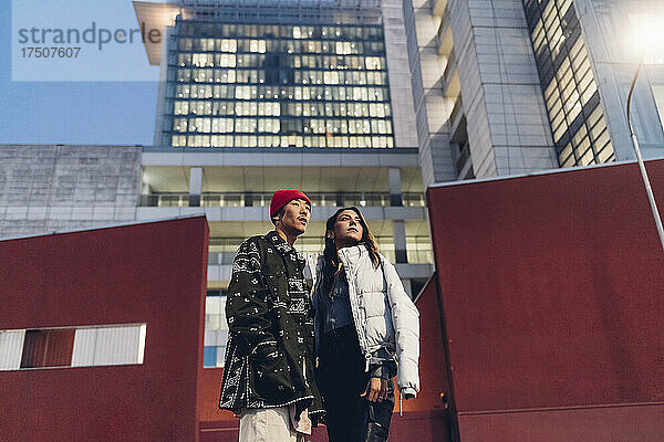 Junges Paar steht vor dem Gebäude