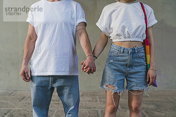 Lesbisches Paar hält Händchen auf Fußweg