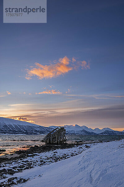 Schiffswrack liegt im Wintermorgen am Ufer des abgelegenen Fjords