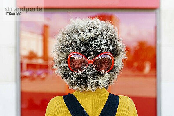 Frau trägt rote Sonnenbrille im Haar