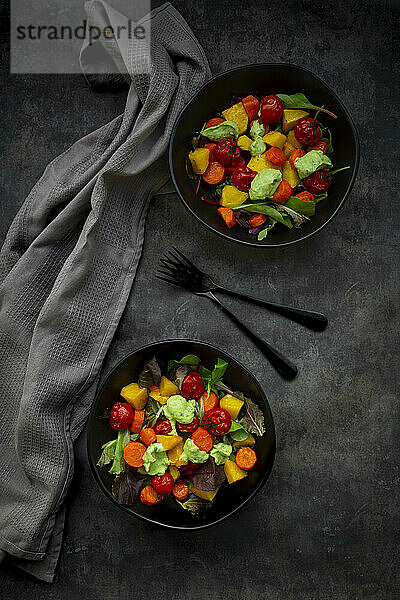Studioaufnahme von zwei Schüsseln veganem Salat mit gebackenem Gemüse