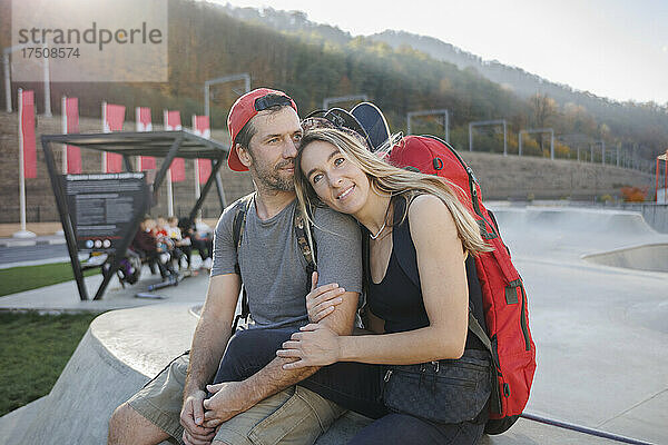 Mann sitzt mit Frau auf Betonwand im Skatepark
