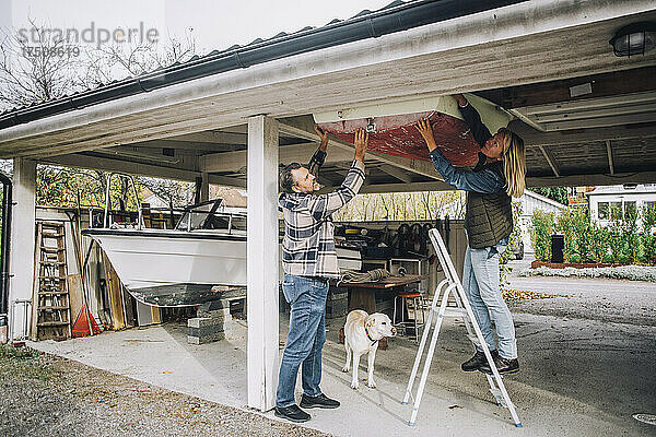 Heterosexuelles Paar beim Binden eines Schiffes in der Garage