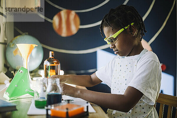 Studentin konzentriert sich bei einem wissenschaftlichen Projekt am Tisch