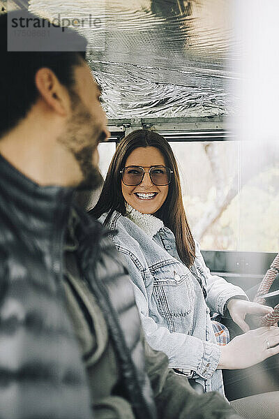 Glückliche männliche und weibliche Freunde sitzen in einem Geländewagen