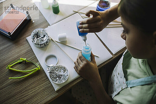 Hohe Winkel Ansicht des Mädchens Mischen von chemischen während der Durchführung wissenschaftliches Experiment am Tisch