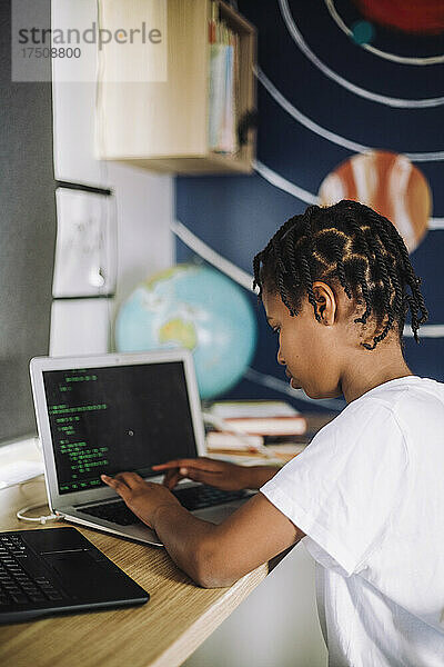 Motiviertes Mädchen lernt zu Hause am Laptop Programmieren