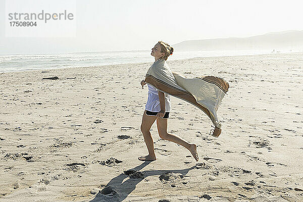 Teenager-Mädchen tanzt auf einem Sandstrand