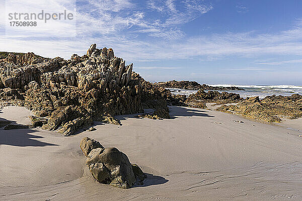 Blick auf einen Sandstrand und Felsformationen an der Atlantikküste.