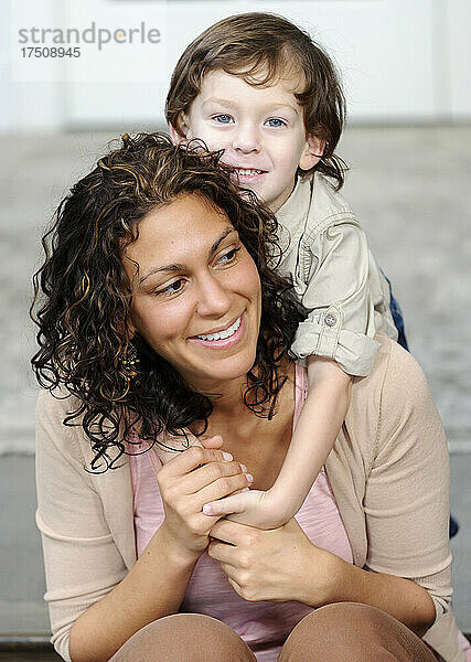 Frau  die einen Jungen umarmt  Mutter und Sonne lachen.
