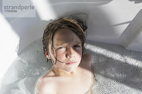 Achtjähriger Junge in einer Badewanne  der ein Bad nimmt