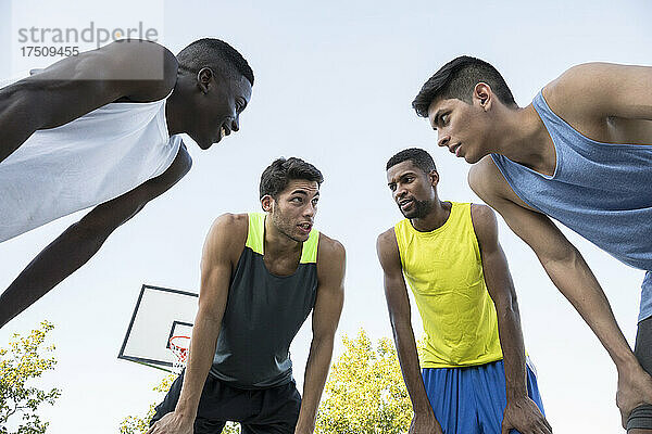 Gruppe von Basketballspielern  die vor dem Spiel über die Strategie diskutieren  Draufsicht