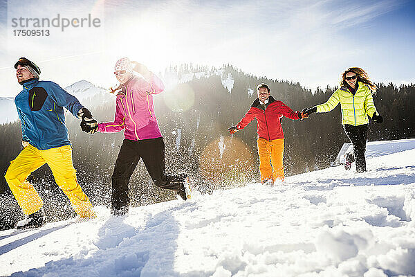 Gruppe unbeschwerter Freunde  die im Schnee laufen und Spaß haben  Achenkirch  Österreich