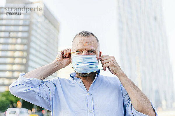Geschäftsmann trägt Gesichtsmaske während des Coronavirus-Ausbruchs in der Stadt