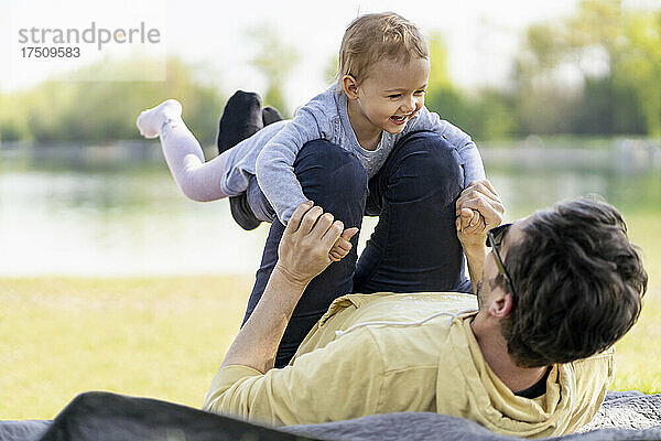 Vater spielt mit seiner kleinen Tochter in einem Park