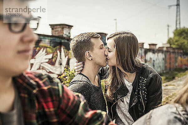 Teenager-Paar küsst sich in einem alten  heruntergekommenen Industriegebiet