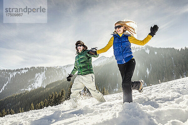 Unbekümmertes Paar läuft durch den Schnee  Achenkirch  Österreich
