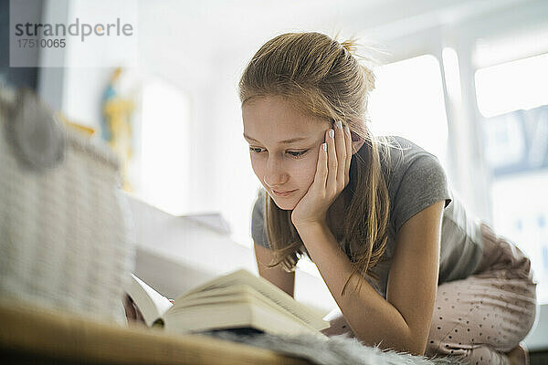 Mädchen liest zu Hause ein Buch
