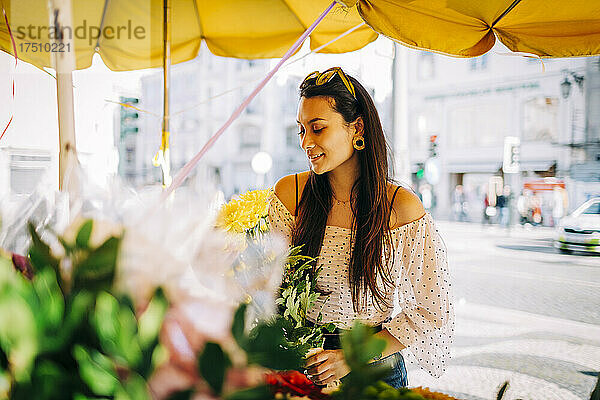 Junge Frau kauft Blumenstrauß im Blumenladen