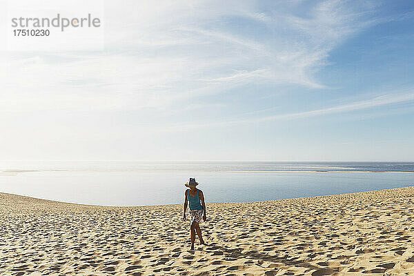 Frau läuft auf Sanddünen am Strand gegen den Himmel  Düne von Pilat  Nouvelle-Aquitaine  Frankreich