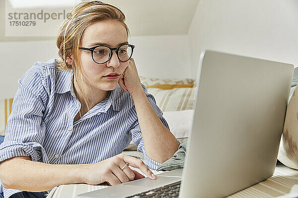 Junge Frau benutzt Laptop zu Hause