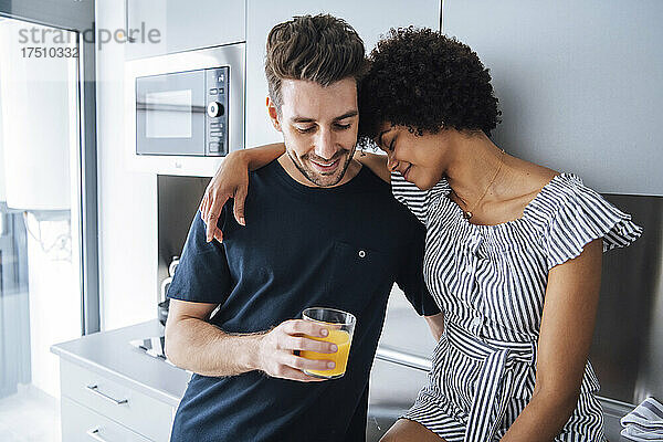 Romantisches multiethnisches Paar in der Küche des Penthouse