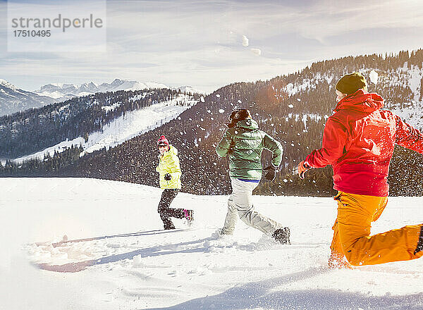 Gruppe unbeschwerter Freunde  die im Schnee laufen und Spaß haben  Achenkirch  Österreich