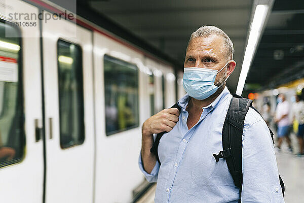 Geschäftsmann mit schützender Gesichtsmaske an der U-Bahn-Station