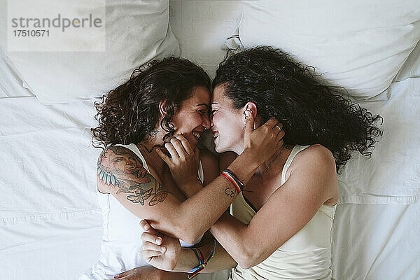 Glückliches lesbisches Paar  das zu Hause im Bett liegt und sich verliebt