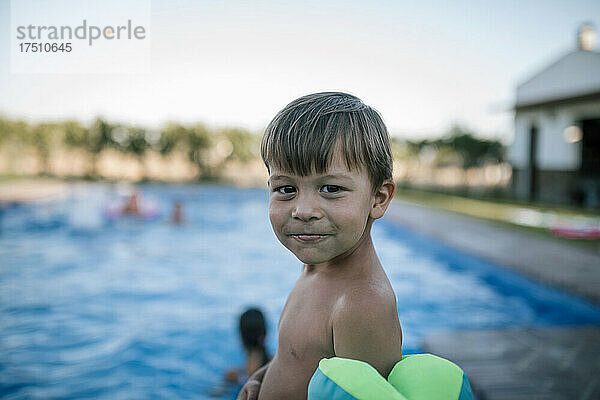 Lächelnder Junge gegen Schwimmbad