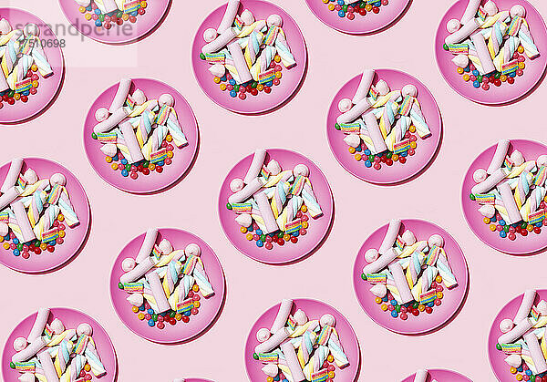Muster aus Plastiktellern mit Marshmallows und Süßigkeiten