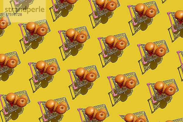 Muster aus frischen Aprikosen in Miniatur-Einkaufswagen