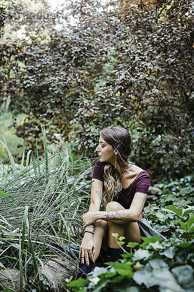 Junge Frau sitzt im Park
