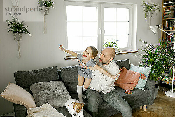 Vater und lachende Tochter spielen zu Hause