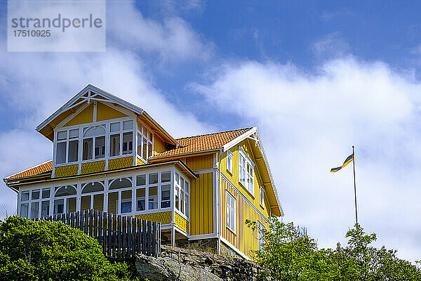 Schweden  Kreis Vastra Gotaland  Fiskebackskil  gelb gestrichenes Ferienhaus im Sommer