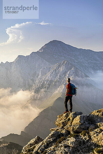 Wanderer steht und bewundert die Aussicht auf die Bergamasker Alpen  Italien