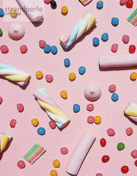 Verschiedene Süßigkeiten vor rosa Hintergrund