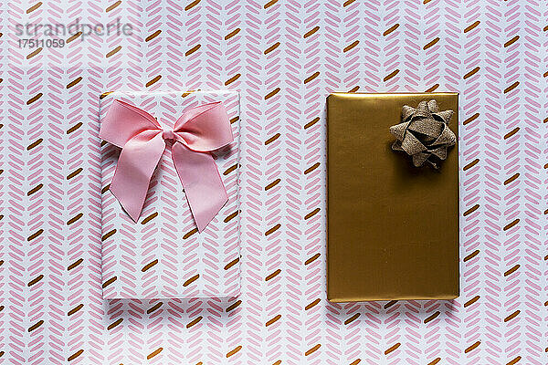 Zwei verpackte Geschenke vor Geschenkpapierhintergrund