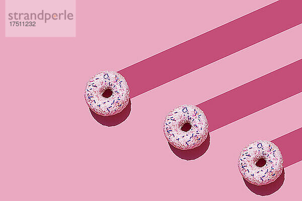 Studioaufnahme von drei süßen Donuts mit Zuckerstreuseln