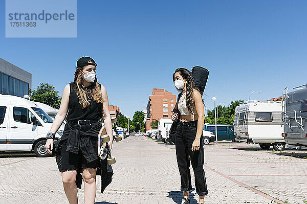 Zwei Frauen mit Schutzmasken gehen auf der Straße