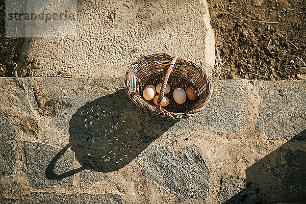 Eier im Weidenkorb über Steinboden
